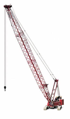 Red construction crane lifting materials on a job site, showcasing heavy machinery in action.