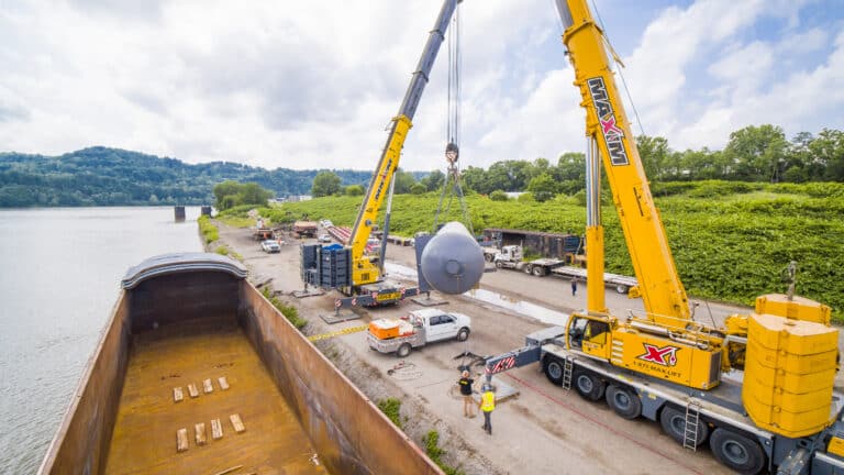 Crane lifting tanks into barge