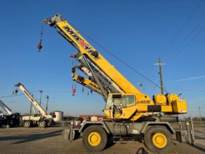 A used crane for sale sitting in a lot with other used cranes