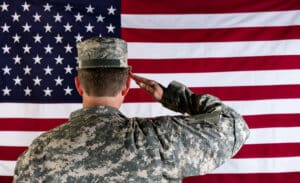 Veteran male solider saluting the flag of USA