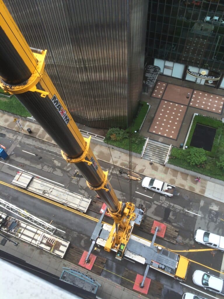 Unique angle looking down at a construction crane with street view.