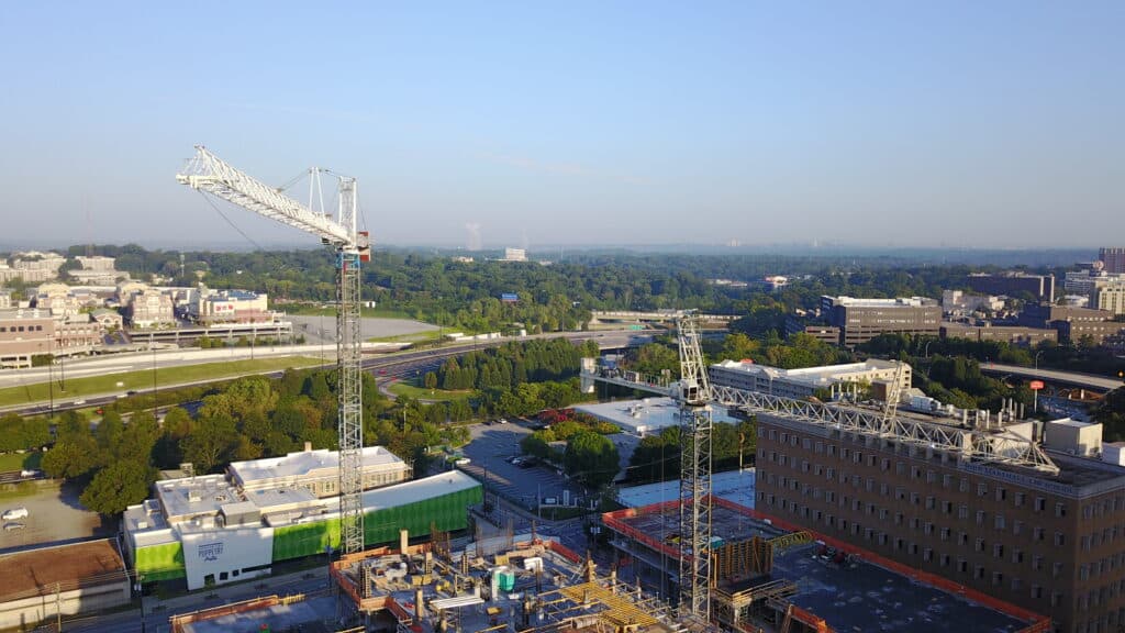 tower cranes on a city project with the town in the background