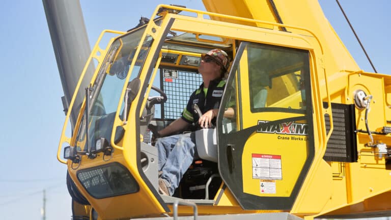 Maxim crane operator inside a crane working on road and bridge construction