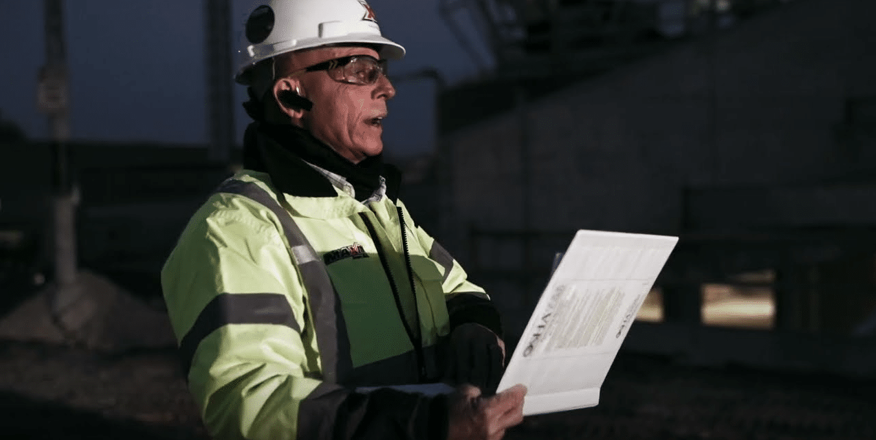 Construction manager reviewing safety checklist on-site for effective project management.
