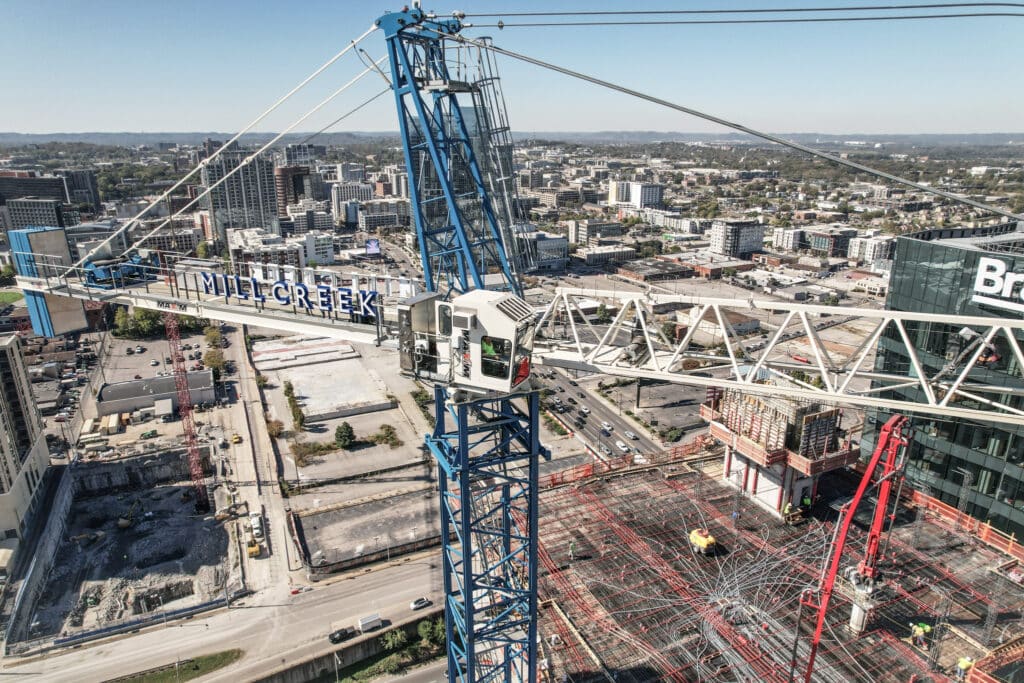 Mill Creek construction crane towers over cityscape with urban development in progress.