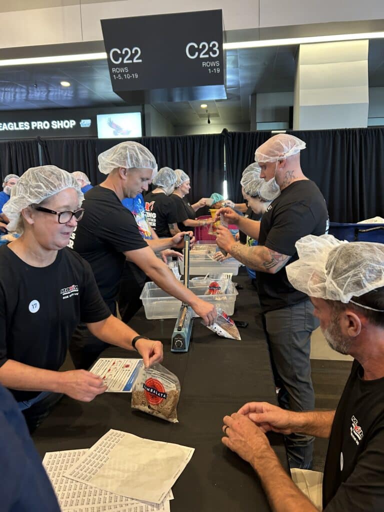 Maxim Crane Volunteers participate in a community service event, packing food for those in need.