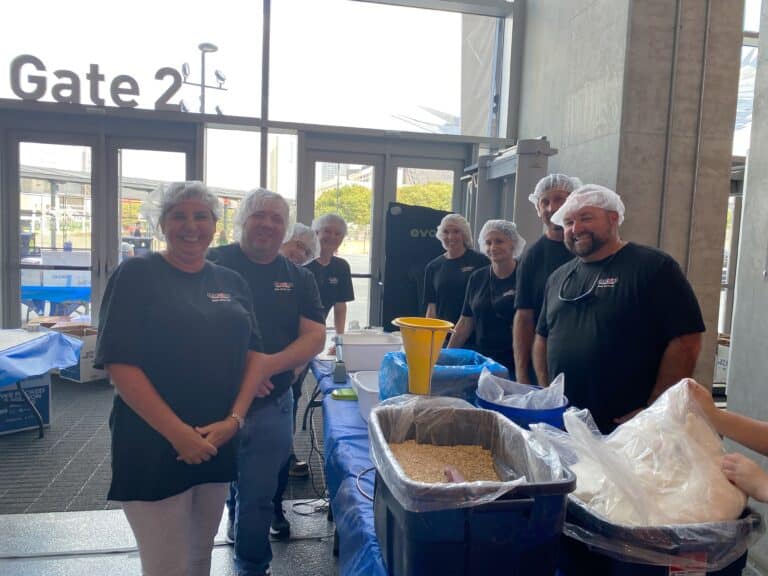 Maxim Crane Volunteers prepare meals together during 9/11 Week of Service, fostering community and teamwork.