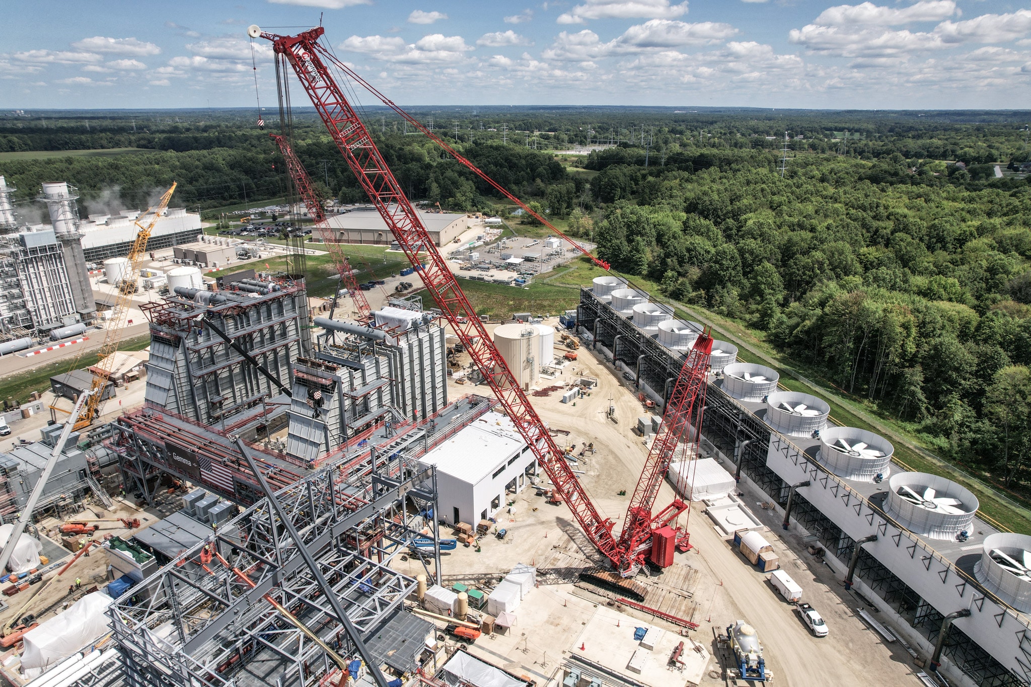 Red Maxim crane efficiently lifting materials at a bustling construction site.