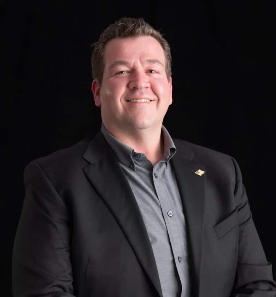 Dave Reed, CIO of Maxim Crane, confidently poses in a business suit.