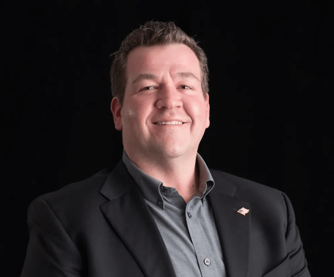 Confident CIO Dave Reed in a sleek black suit, showcasing professionalism and leadership.