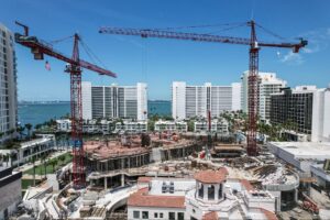 Miami skyline construction with cranes at a coastal development site.