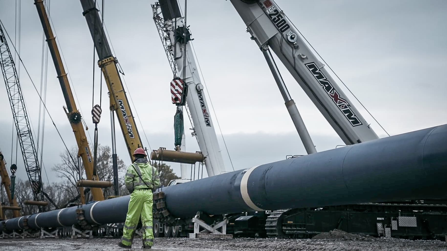 Cranes lifting large pipes for infrastructure development at the Platte River site.