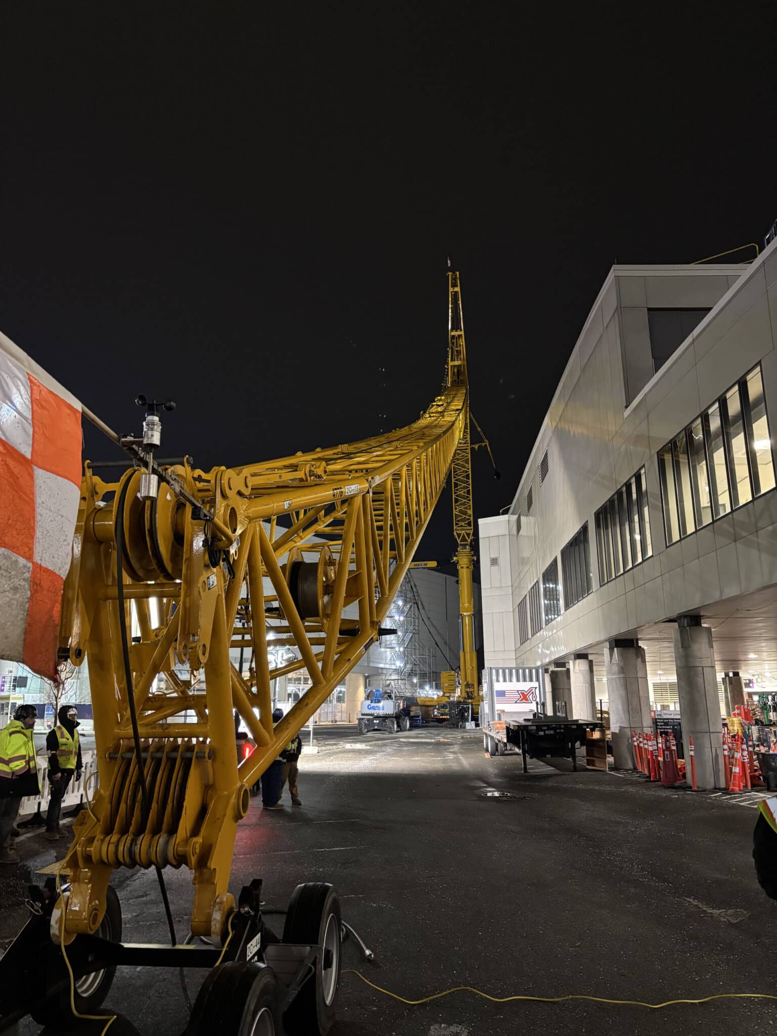 Yellow crane illuminated against the night sky near Logan Airport.