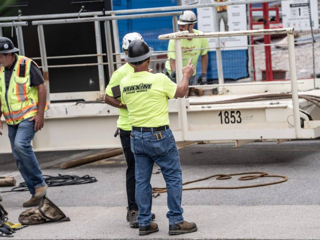 Maxim Crane team members collaborate safely during on-site operations.