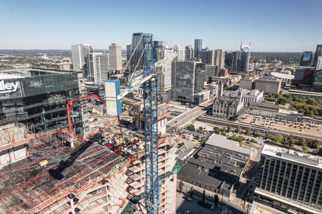 Construction site amidst modern skyscrapers in a vibrant city skyline.