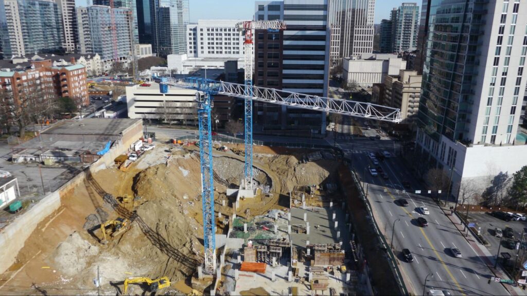Crane operating on a construction site in a busy urban landscape.