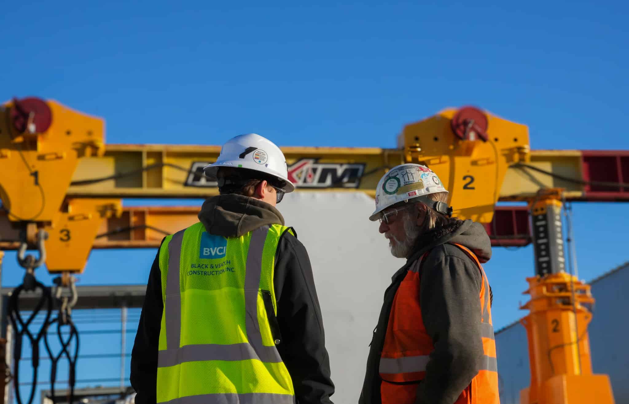 Construction workers discussing safety measures and project plans at a job site.