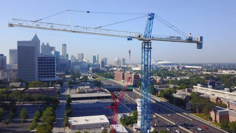 Aerial view of a construction crane overlooking a bustling city landscape.