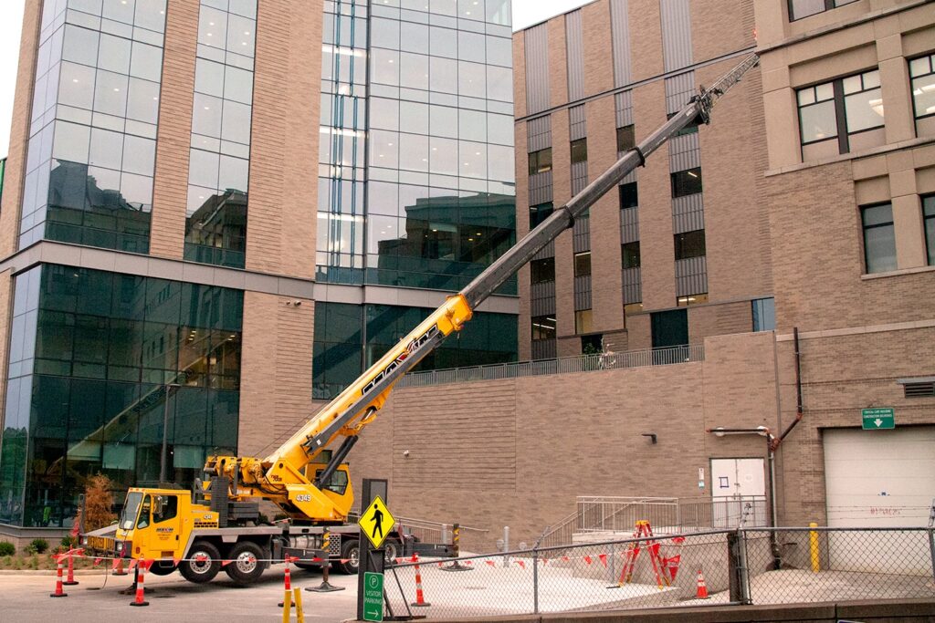 Construction crane at a building site lifting materials for high-rise development.