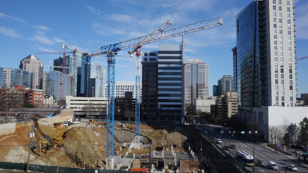 Urban construction site progress with cranes and buildings in a bustling cityscape.