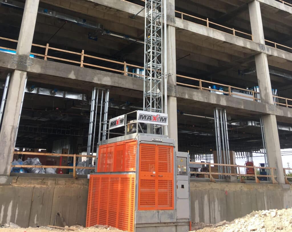 Construction elevator setup for efficient building project with MAXIM equipment at the site.