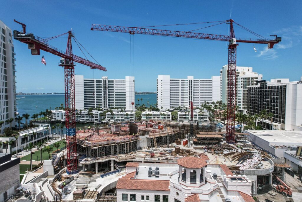 Aerial view of a bustling construction site with cranes and modern buildings.