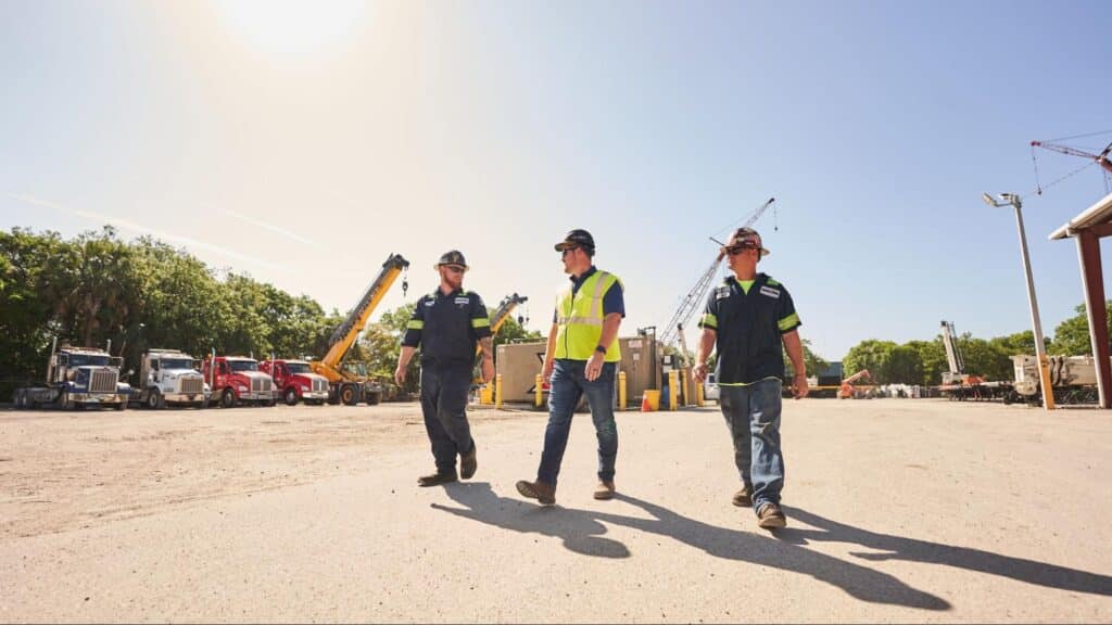 Construction workers walking on-site, overseeing operations and equipment.